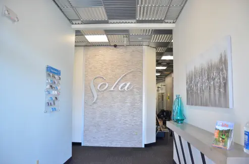 The main entrance hallway. A stylized stone wall can be seen with large metal letters that read 'Sola'